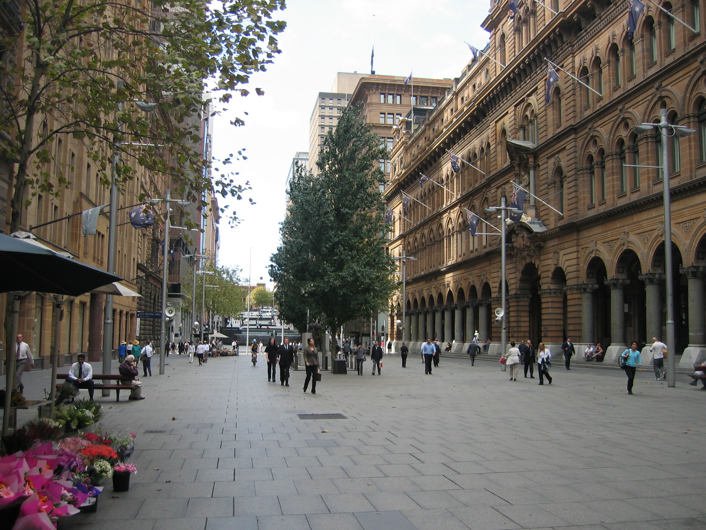 Real photograph of pedestrians walking through Martin Place, Sydney. Illustrative corner brackets align with visible people, with example movement paths beneath them. These annotations are not measured tracking data.